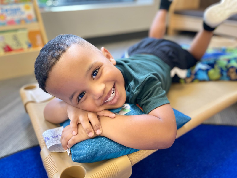 Happy preschool boy on cot at Lionheart Children's Academy
