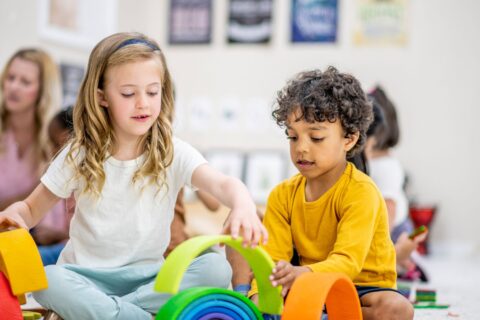 Young girl and boy playing with toys together