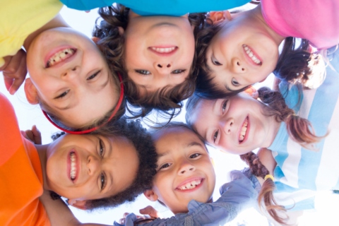 Group of smiling children forming a circle outside in Texas