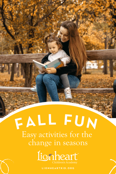 Mother with daughter on lap reading a book on a bench in autumn
