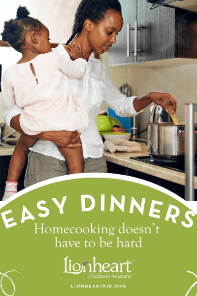 Mother holding daughter while cooking